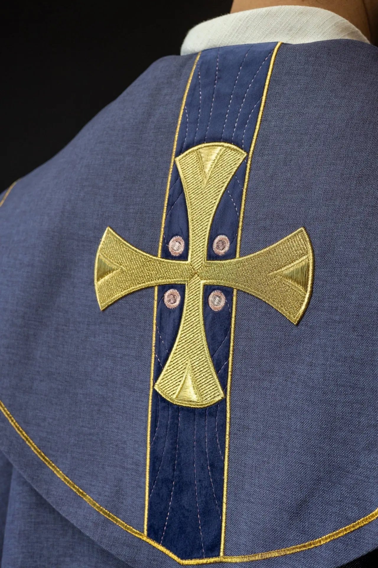 Capa litúrgica con cruces bordadas en oro y cuello de terciopelo púrpura