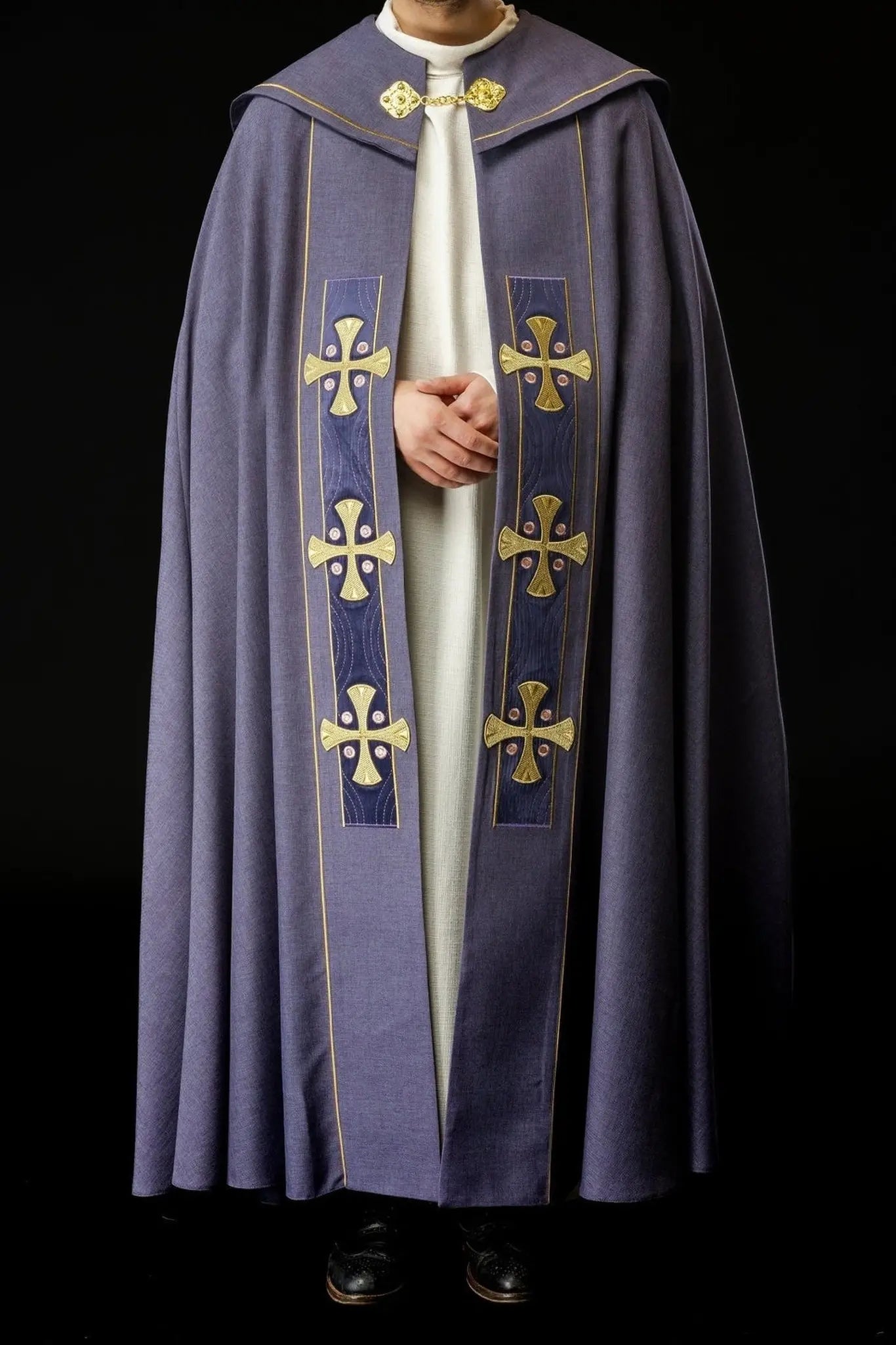 Capa litúrgica con cruces bordadas en oro y cuello de terciopelo púrpura