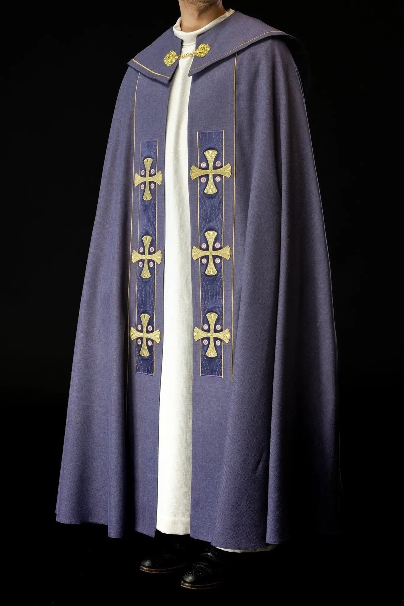 Capa litúrgica con cruces bordadas en oro y cuello de terciopelo púrpura