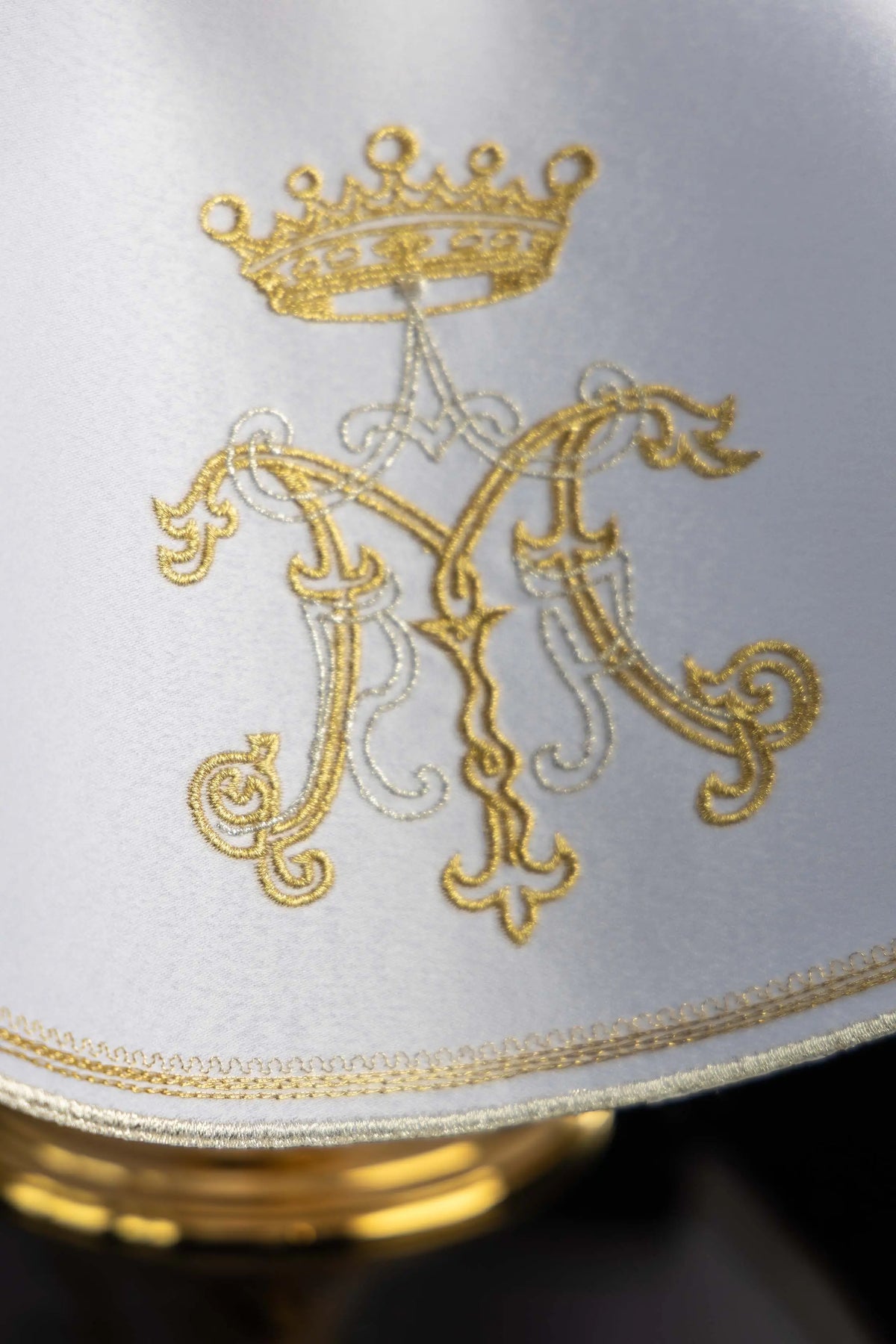 Blanco cubrecopón con monograma de María bordado, detalle frontal