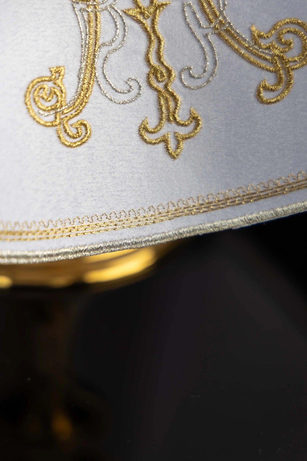 Blanco cubrecopón con monograma de María bordado, detalle del ribete