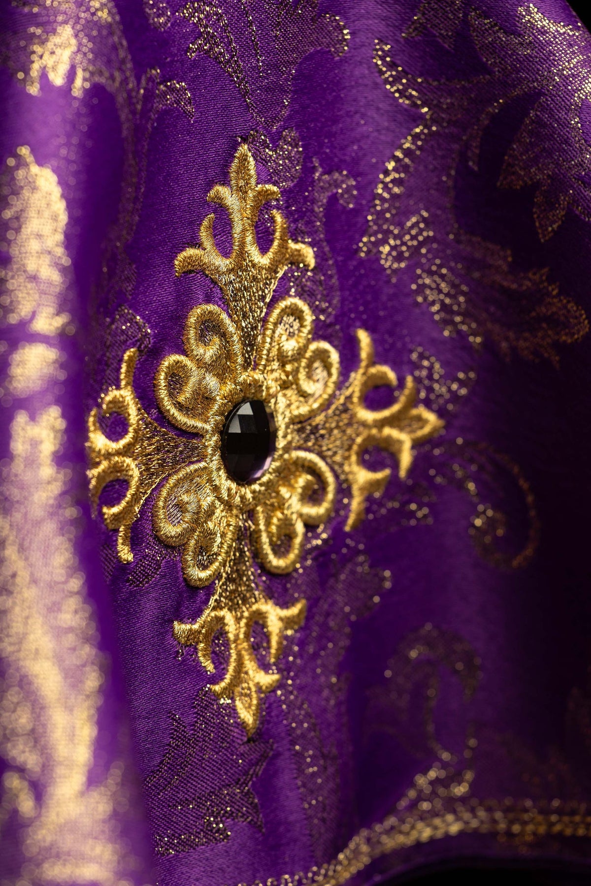 Cubrecopón morado con cruz bordada dorada, detalle del bordado