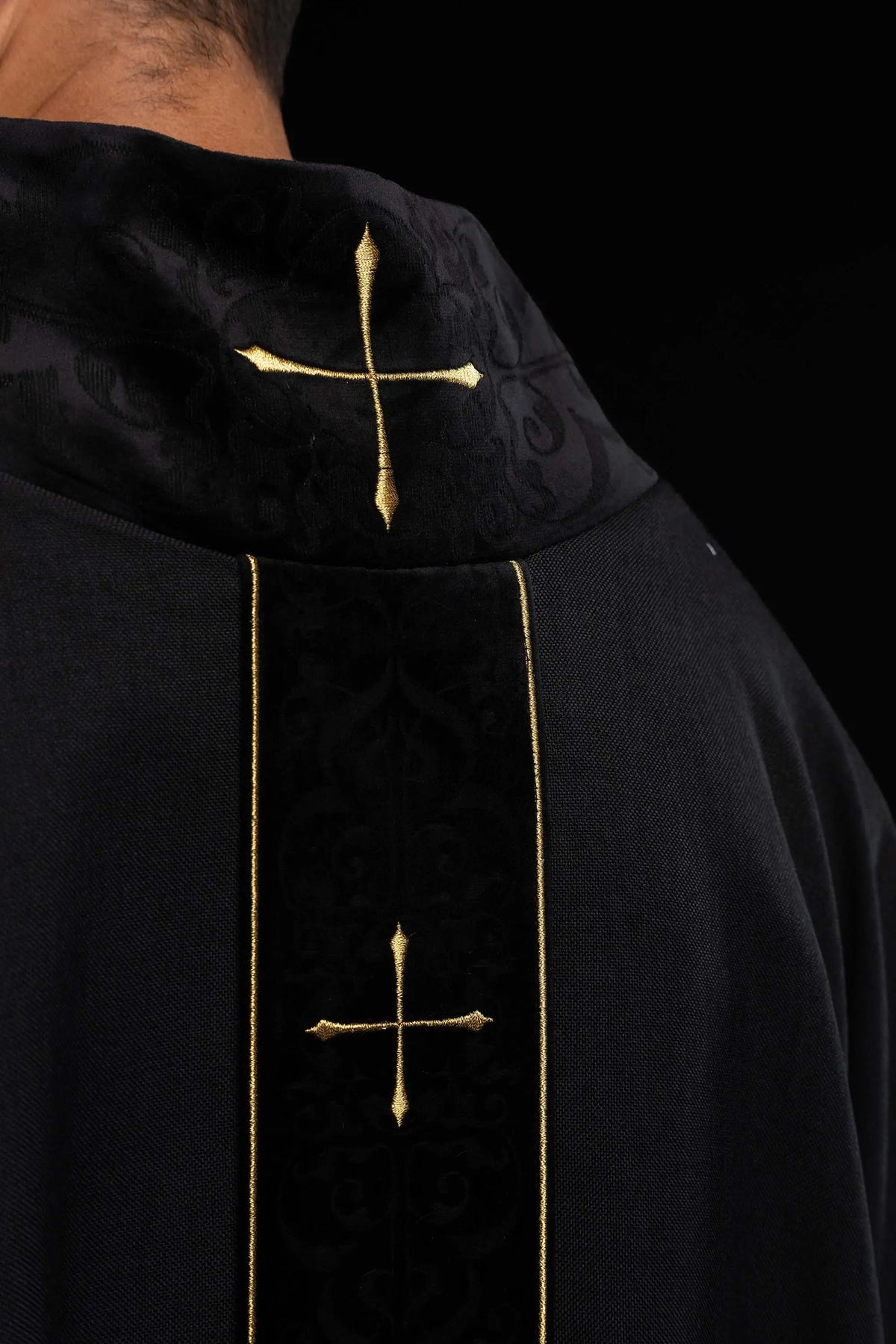Negro casulla litúrgica con cruz dorada y galón central, detalle del cuello