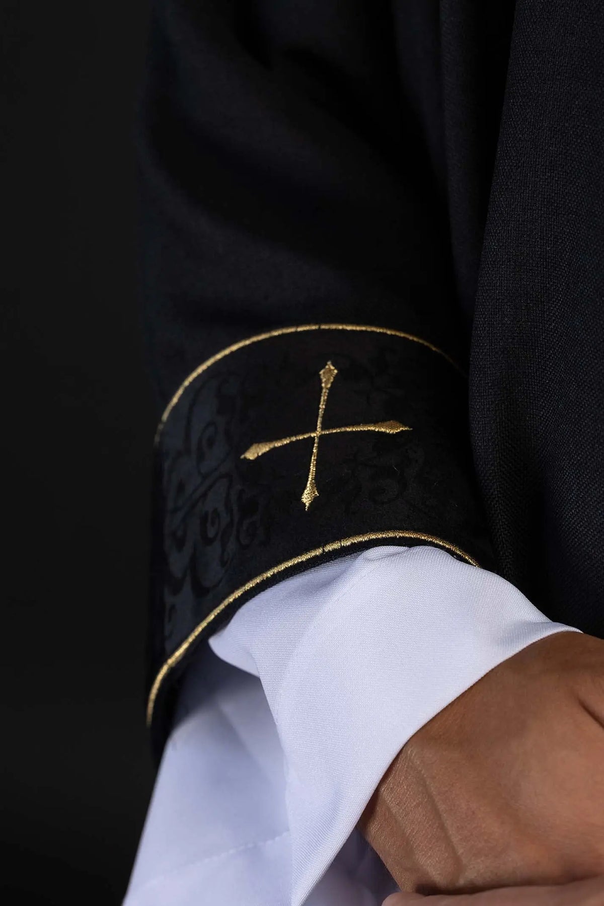 Negro casulla litúrgica con cruz dorada, detalle del ribete de la manga