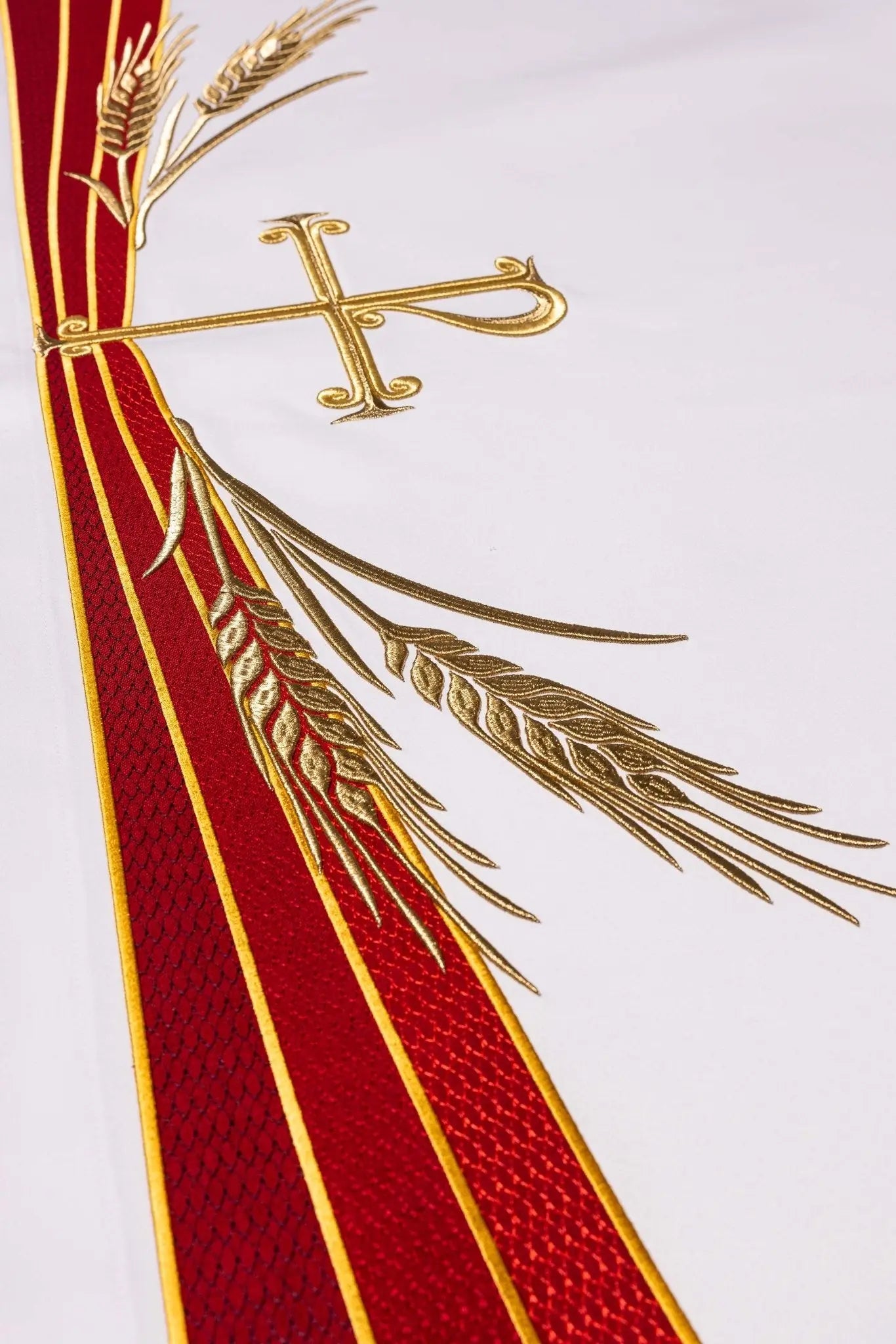 White altar cloth with embroidered Pax symbol, golden wheat sheaves, and red and gold trim