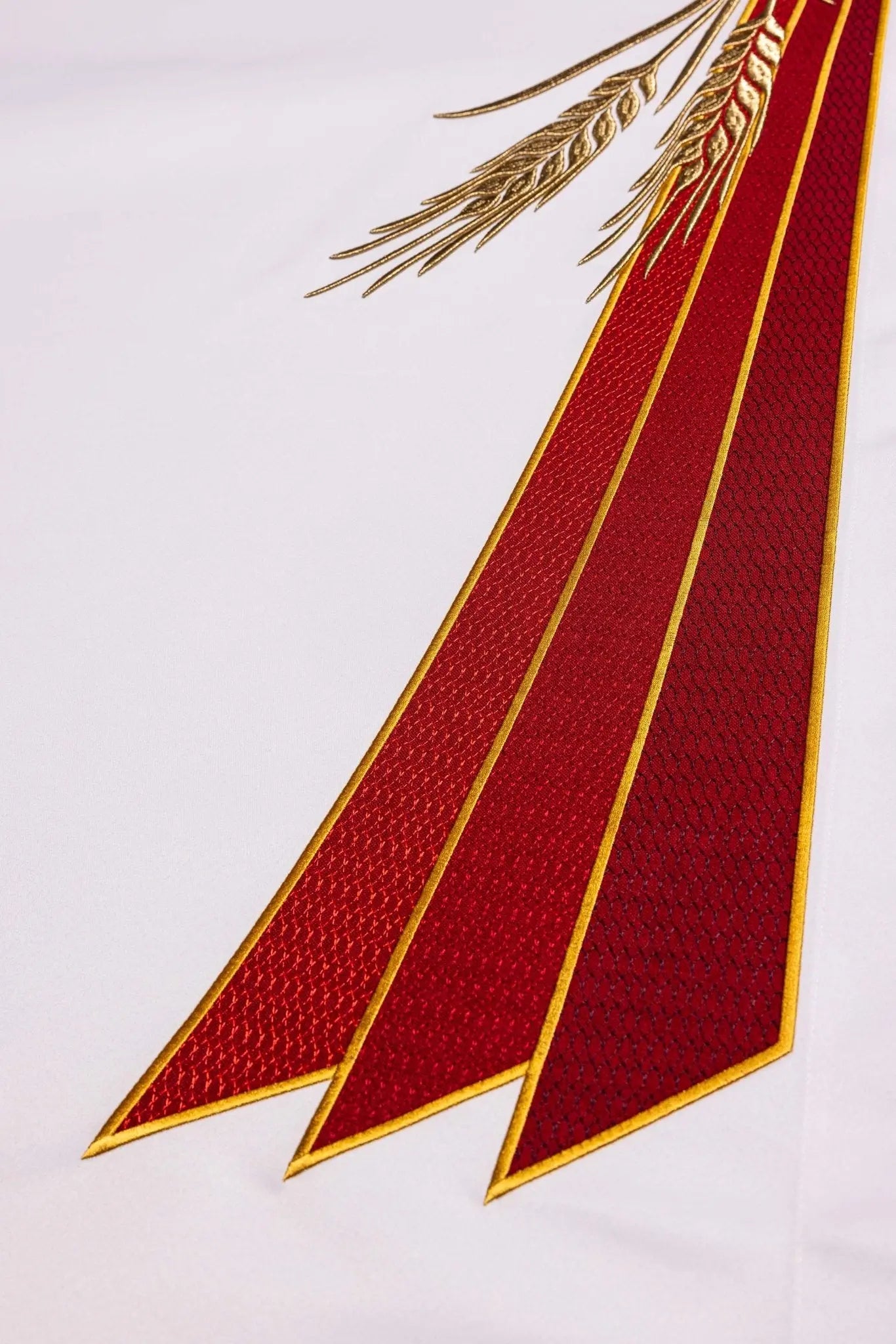 White altar cloth with embroidered Pax symbol, golden wheat sheaves, and red and gold trim