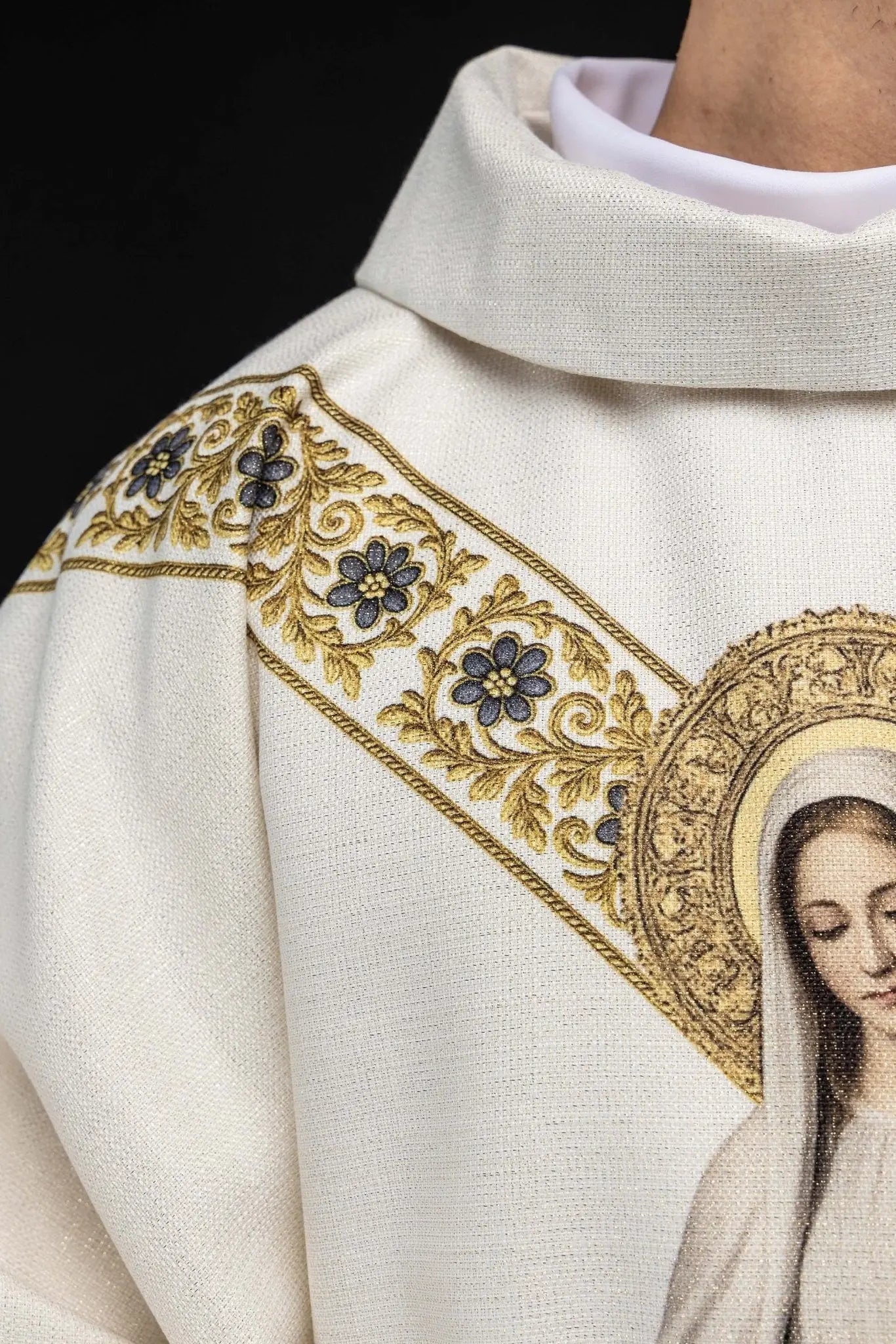Ecru chasuble with printed image of Our Lady of Lourdes, featuring a blue sash and gold floral motifs, with a matching stole.