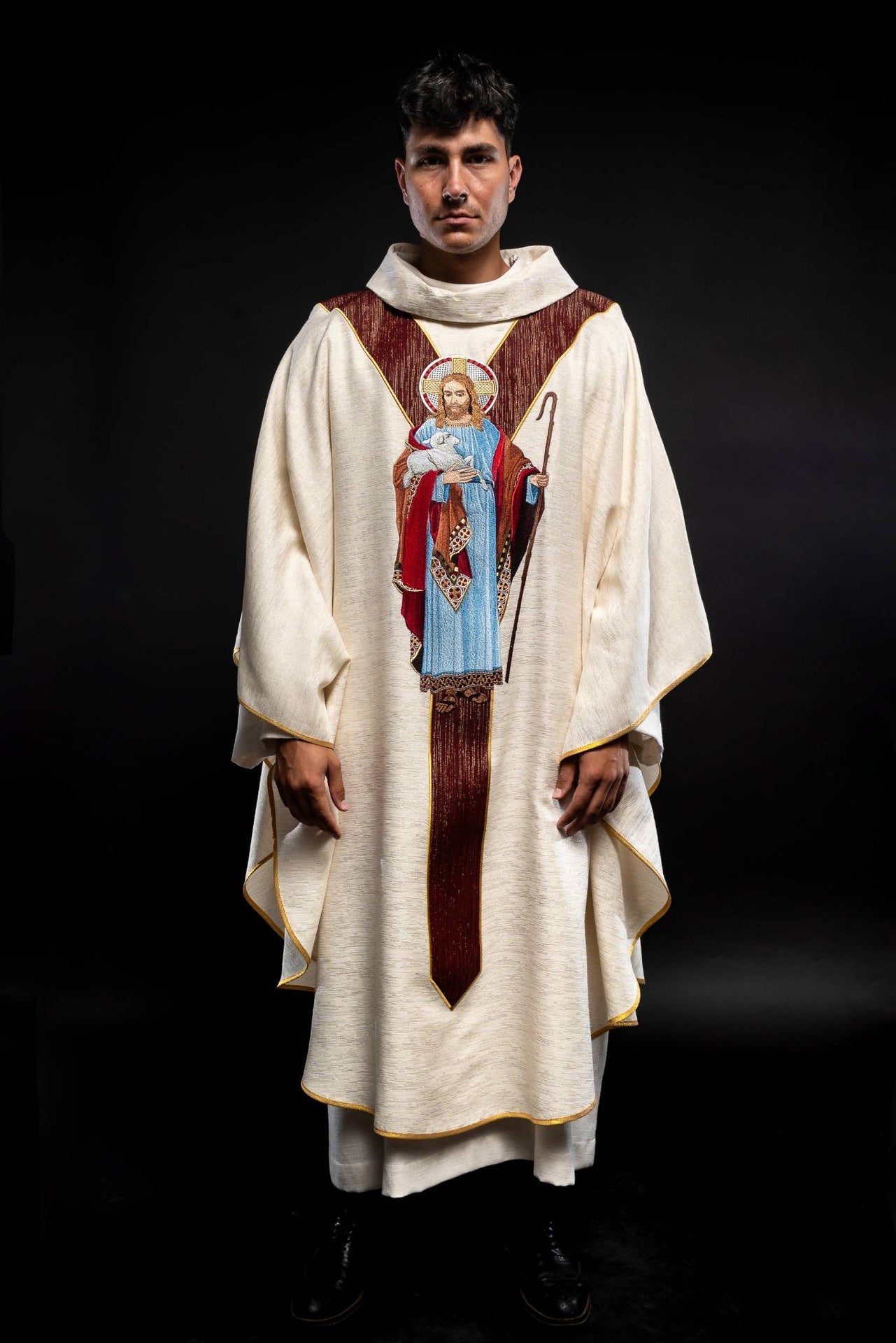 Ornat ecru z wizerunkiem Jezusa Dobrego Pasterza z ozdobnym bordowym pasem