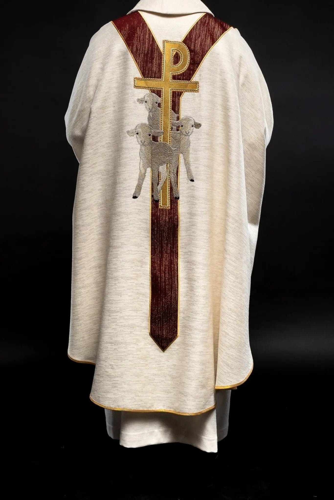 Casulla ecru con la imagen de Jesús el Buen Pastor con una franja decorativa burdeos