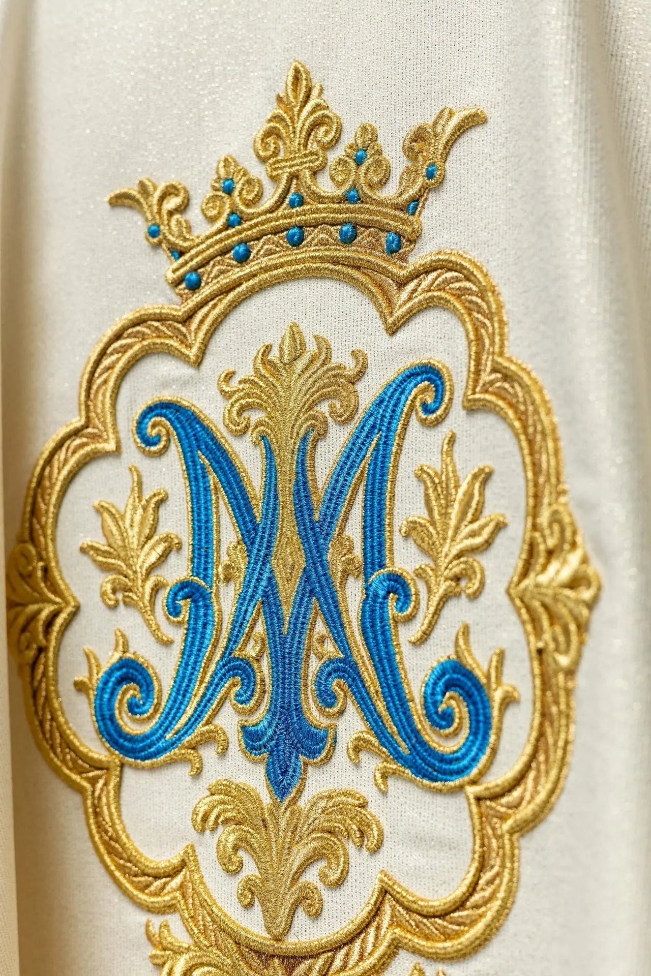 Casulla litúrgica con escudo mariano bordado y corona