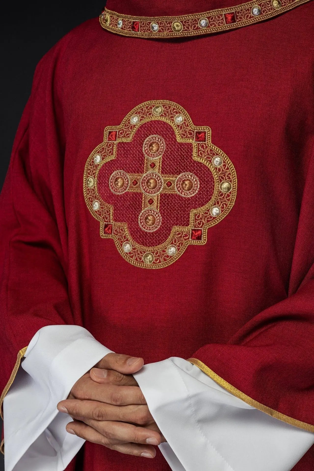 Casulla roja con ribete bordado en el cuello y alrededor del bordado de la cruz