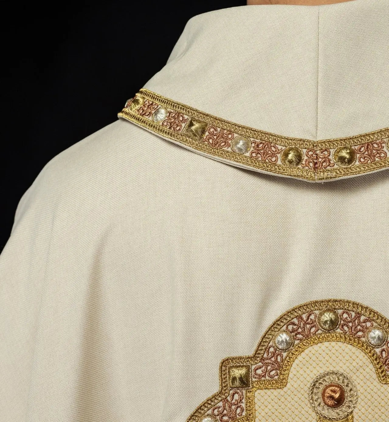 Chasuble in ecru color with embroidered trim on the collar and around the embroidery of the cross